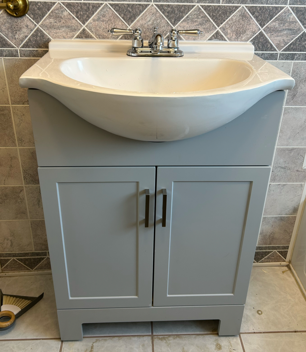 Newly installed bathroom vanity with a chrome faucet and porcelain sink, freshly finished